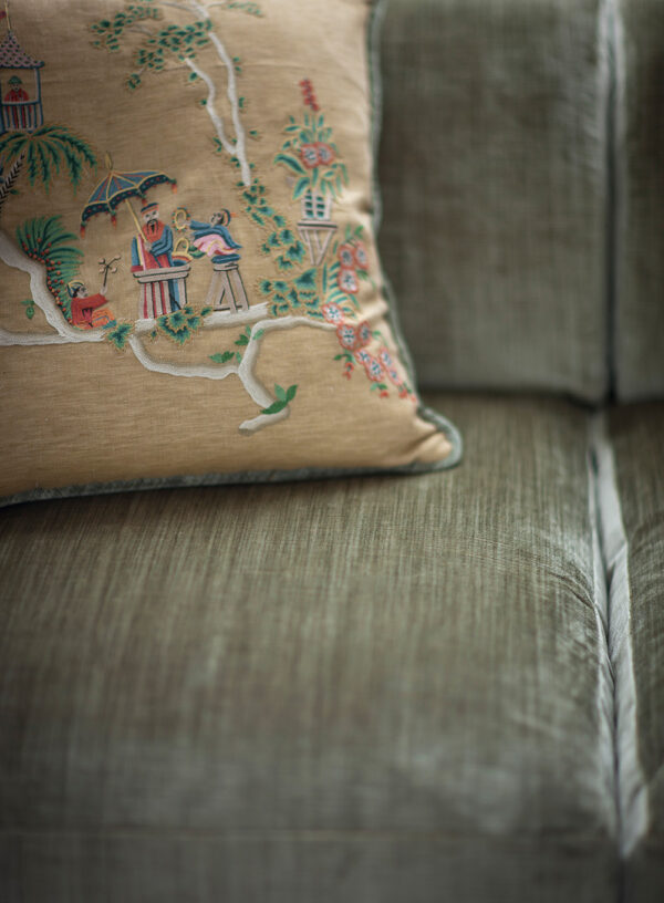 Bespoke, handmade low back sofa in green velvet with embroidered cushions.