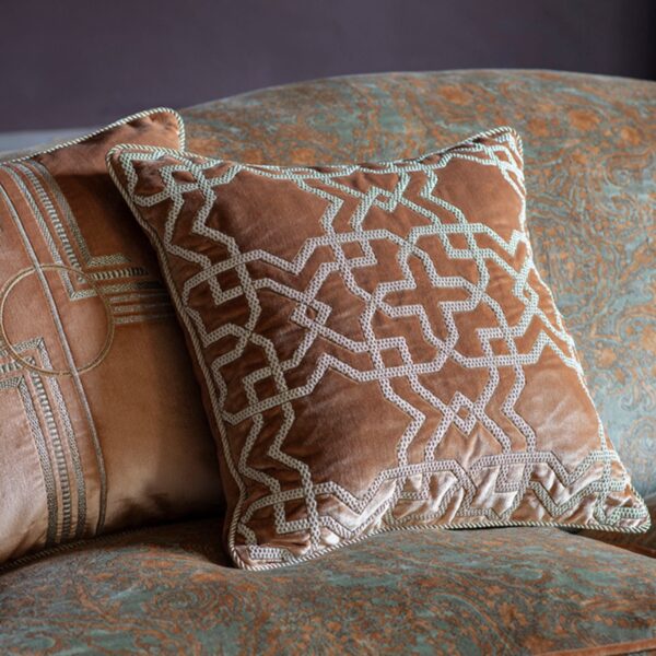 A collection of luxurious hand embroidered cushions on a sofa