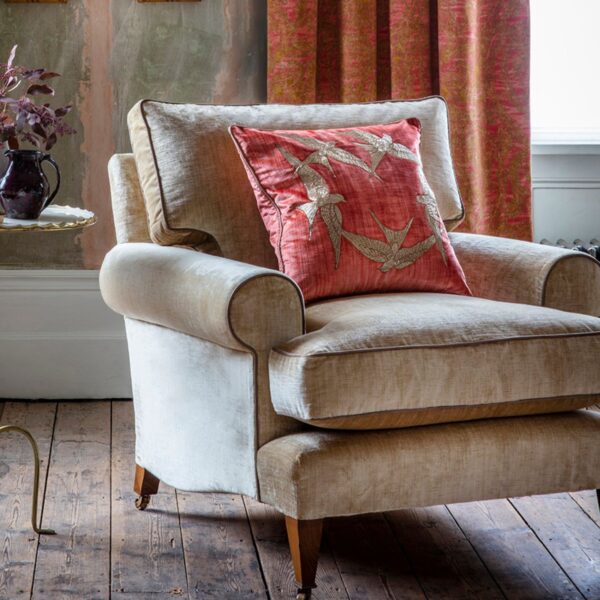 A luxurious, red velvet cushions with a striking hand embroidered design on the front