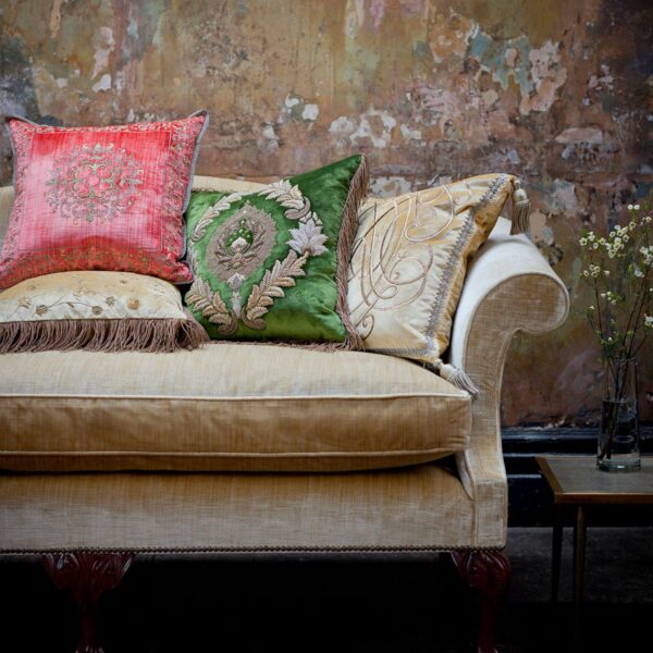 A collection of luxurious hand embroidered cushions on a Chippendale style sofa