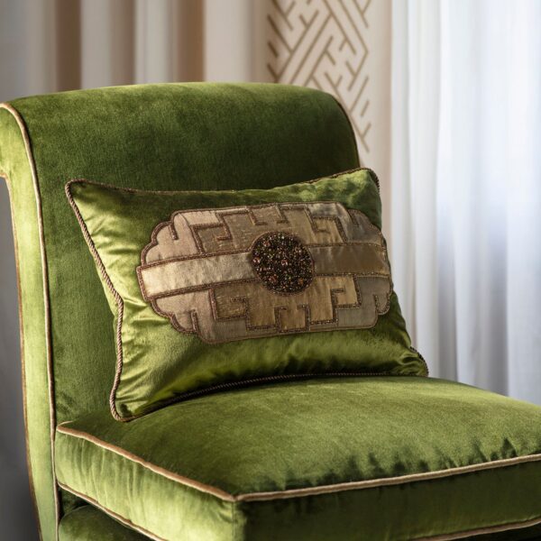 A green silk velvet cushion with a art deco inspired hand embroidery design on the front