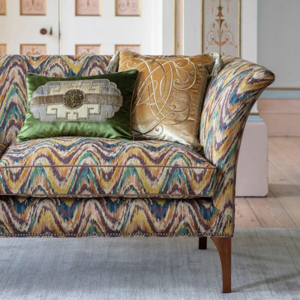 A collection of hand embroidered cushions on an elegant sofa upholstered in a flame stitch fabric