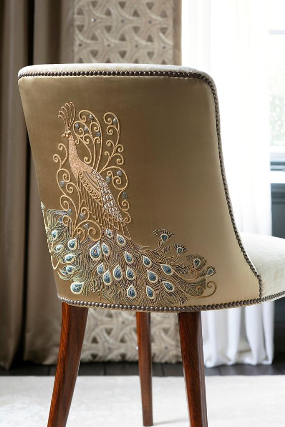 A luxurious upholstered dining chair with embroidery on the back