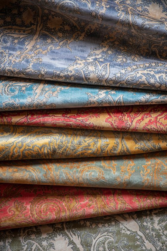 A swatch of printed cotton velvet upholstery fabric with a paisley design in a range of colours.